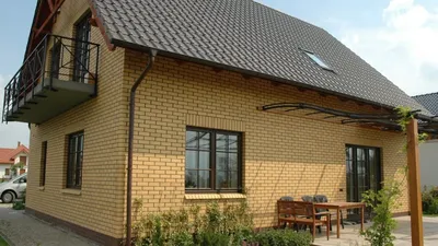 Изображение кирпичного дома с зеленым газоном