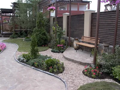 Клумба с солнечными цветами во дворе частного дома