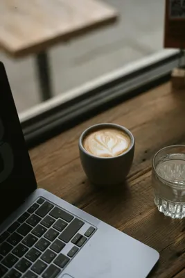 Earbuds with notebook and coffee near laptop stock photo