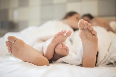 лесбийская пара лежит в постели под белыми одеялами Стоковое Фото -  изображение насчитывающей уютный, усмехаться: 224878640