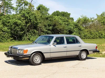 Mercedes-Benz 450SEL 6.9 на фоне заката над городом