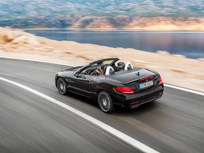 Фотография черного Mercedes-Benz SLC-класса на фоне зданий