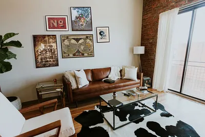 Картины и постеры над диваном в интерьере гостиной в стиле лофт, фото
