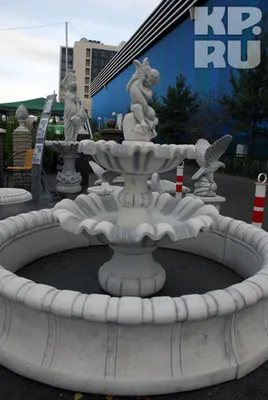Фото загородного дома с красивыми статуями и зелеными деревьями